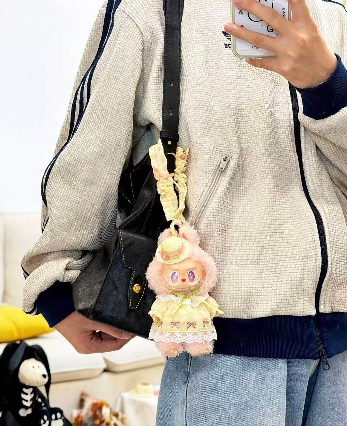 POP MART MOKOKO plush pendant in a yellow dress and straw-style hat hanging from a black shoulder bag